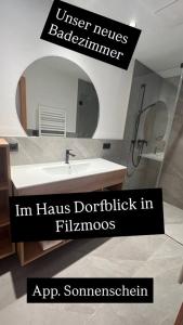 a bathroom with a sink and a mirror at Haus Dorfblick in Filzmoos