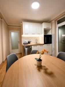 a kitchen with a large wooden table with chairs and a tableasteryasteryasteryastery at Royal Apartmani in Negotin
