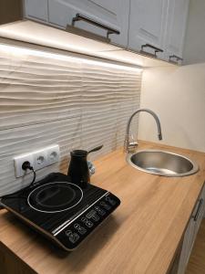 a kitchen counter with a stove and a sink at Royal Apartmani in Negotin +27 photos