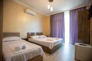 a hotel room with two beds and a window at Guest House on Rustaveli 176 in Kobuleti