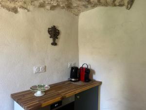a wooden table with a coffee maker on a wall at Ancienne eglise in Vallérargues