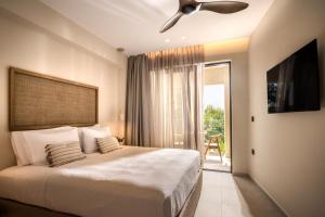 a bedroom with a bed and a ceiling fan at Natalie Hotel in Laganas +37 photos