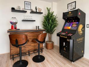 a bar with two chairs and a pinball machine at Depa Penthouse en Juriquilla con terraza y alberca climatizada in Juriquilla