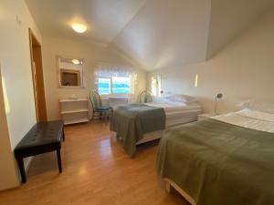 a bedroom with two beds and a table and a desk at Öndólfsstaðir Farm B&B in Laugar