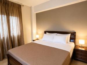 a bedroom with a large bed with two lamps at Hermes Casa Hersonissos in Hersonissos