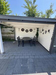 a patio with a table and chairs in a garage at Beach Chalet Sunny Dunes in Petten
