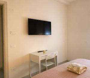 a bedroom with a desk and a tv on the wall at Borgo San Michele Bed & Breakfast in Calvisano