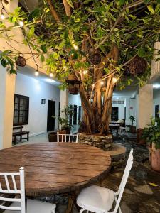a wooden table with chairs and a tree with lights at Hotel Puerta de Jade in Ciudad Valles