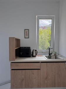 a kitchen with a sink and a window at Villa Thalassa Lal'Andrea in Dhërmi
