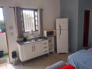 a small kitchen with a sink and a refrigerator at Quarto superior Privativo in Itupeva
