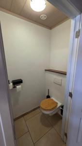 a bathroom with a toilet with a wooden seat at Gîte citadin de l'Entreville in Lobbes
