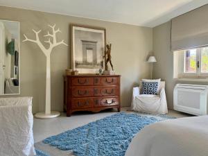 a bedroom with a dresser and a tree on the wall at La Casetta in riva al mare in Quercianella