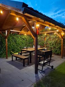 a wooden pergola with benches and tables under it at Villa Cork in Dębki