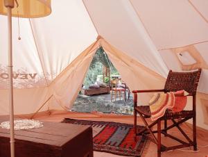 a room with a tent with a chair and a table at Wishne Glamping Agriturismo in tende Bisceglie in Bisceglie