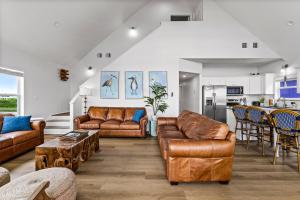 a living room with leather furniture and a kitchen at Spacious Beachfront 5BR with Gorgeous Ocean views - Blue Footed in Bolivar Peninsula