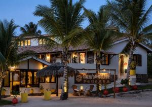 a resort with palm trees in front of it at Samba Pousada in Jericoacoara