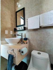 a bathroom with a white toilet and a sink at CasaMEXH Lunamar - Despierta, toma café en la 5ta Av, explora Xcaret, experimenta Tulum o algún cenote cercano - Unas vacaciones extraordinarias para tu familia y tus amigos in Playa del Carmen +35 photos