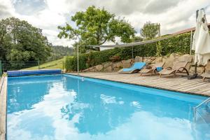 a large swimming pool with chairs and a deck at Dienberger Ferienhaus in Untergriesbach