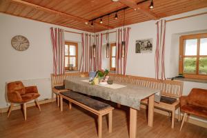 a dining room with a table and chairs and a clock at Dienberger Ferienhaus in Untergriesbach