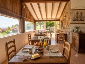 a dining room with tables and chairs and windows at B&B Arghjola in Porto-Vecchio