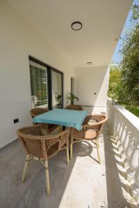 a patio with a table and chairs on a balcony at Olivium Rooms in Vlorë