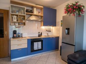 a kitchen with blue cabinets and a refrigerator at Apartman"Petra" in Krk