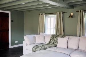 a living room with a white couch and a window at Rose Cottage - Sands Farm in Wilton +18 photos