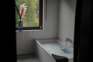 a bath tub in a bathroom with a window at Emotion Apartments- Erlebnis Apartment mit privater Sauna und Whirlpool in Vlotho +20 photos