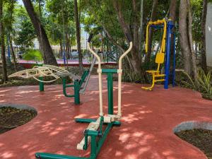 a park with a playground with a swing at CasaMEXH Veredas - Tu refugio familiar entre la selva, cenotes y la playa, vive tus vacaciones lejos del turismo masivo, a 10 Min de la ruta de los cenotes y el arrecife más cercano de la Riviera Maya - A 20 min de Cancún y Playa del Carmen in Puerto Morelos
