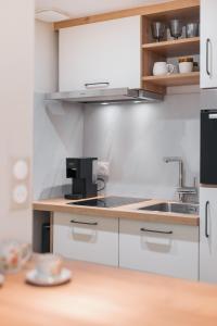 a kitchen with white cabinets and a sink at Villa Raphia - Maison d'hôtes in Hardelot-Plage