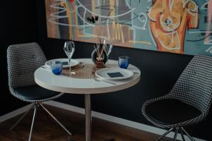 a table with two chairs and a plate and wine glasses at Emotion Apartments- Erlebnis Apartment mit privater Sauna und Whirlpool in Vlotho