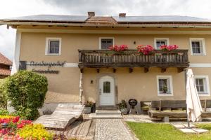 a house with a balcony with flowers on it at Dienberger Ferienhaus in Untergriesbach