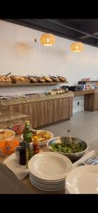 a kitchen with plates of food on a counter at Hotel Ponto 1 in Vacaria
