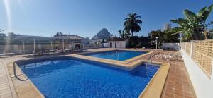 a swimming pool in the middle of a house at Paraíso Familiar en Marisol Park Bungalow con Piscina, Tenis y Parking in Calpe