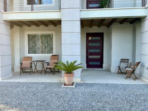 Villa Babilonia في Alvisopoli: شرفة بها طاولة وكراسي وباب
