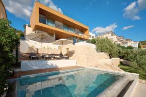 a house with a swimming pool next to a building at Aparatment house Gloss Primosten in Primošten