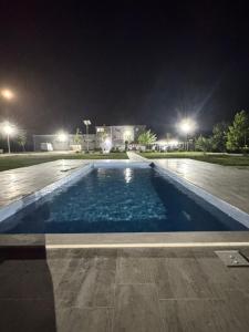 an empty swimming pool at night with lights at Kostovski Rooms-near E75 to Greece in Veles