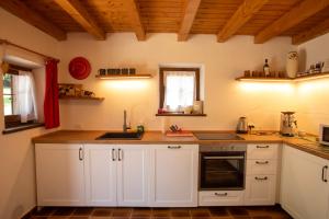 a kitchen with white cabinets and a sink at Casera Marisa Nevegal in Nevegal +32 photos