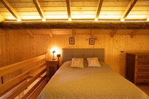 a bedroom with a bed in a wooden room at Casera Marisa Nevegal in Nevegal