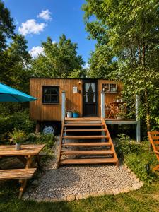 a tiny house with a deck and a table at Maringotka Pomněnka in Pačejov