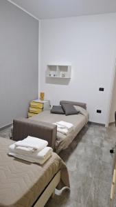 zwei Betten in einem Zimmer mit weißen Wänden in der Unterkunft Casa Lab in Senise