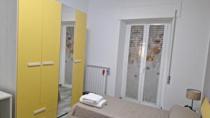 ein kleines Zimmer mit gelber Tür und einem Bett in der Unterkunft Casa Lab in Senise