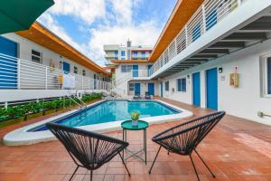 a swimming pool with two chairs and a table in front of a building at Studio with Balcony and Parking - M47 in Hollywood