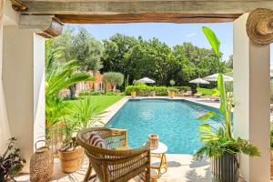 an outdoor patio with a swimming pool and chairs at Maison Casasand Maison d'hôtes de charme in Grasse