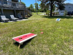 a red and white surfboard sitting in the grass at Waterfront Escape with Stunning Views on Bass River in West Dennis