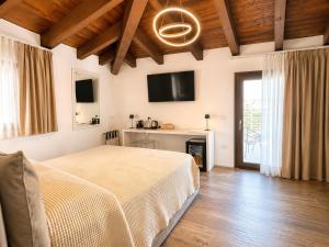 a bedroom with a bed and a tv on the wall at Astra - Exclusive Rooms in Castelsardo