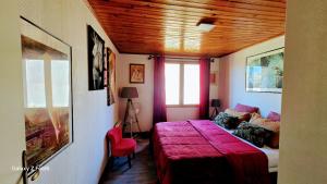 a bedroom with a bed with a red blanket at Chambres Du Petit Bonheur in Biscarrosse