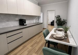 a kitchen with a table and chairs in a kitchen at Apartament modern cu dormitor separat si balcon panoramic in Căuşeni