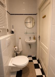 a white bathroom with a toilet and a sink at Manor Suite Amsterdam in Amsterdam +5 photos