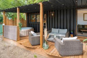a deck with wicker chairs and a hot tub at Ô Temps Des Pins in Éguilles